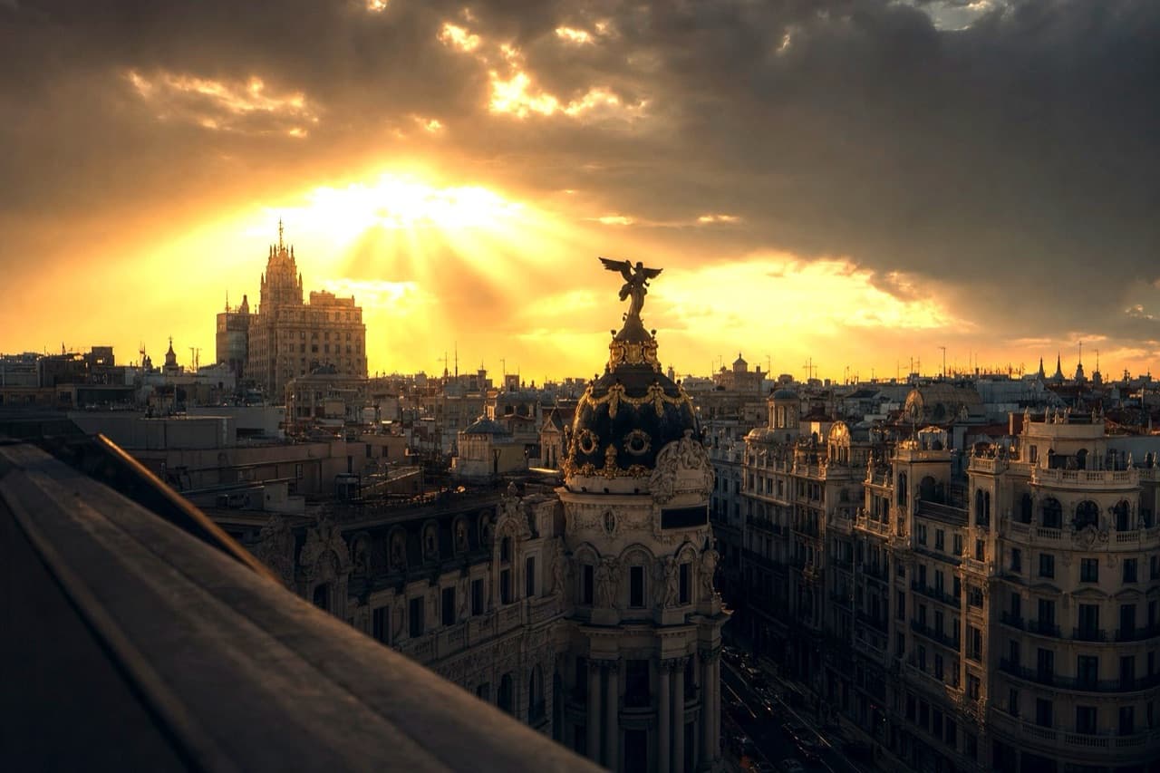 Madrid rooftops at sunset with the dome of the Metrópolis building
