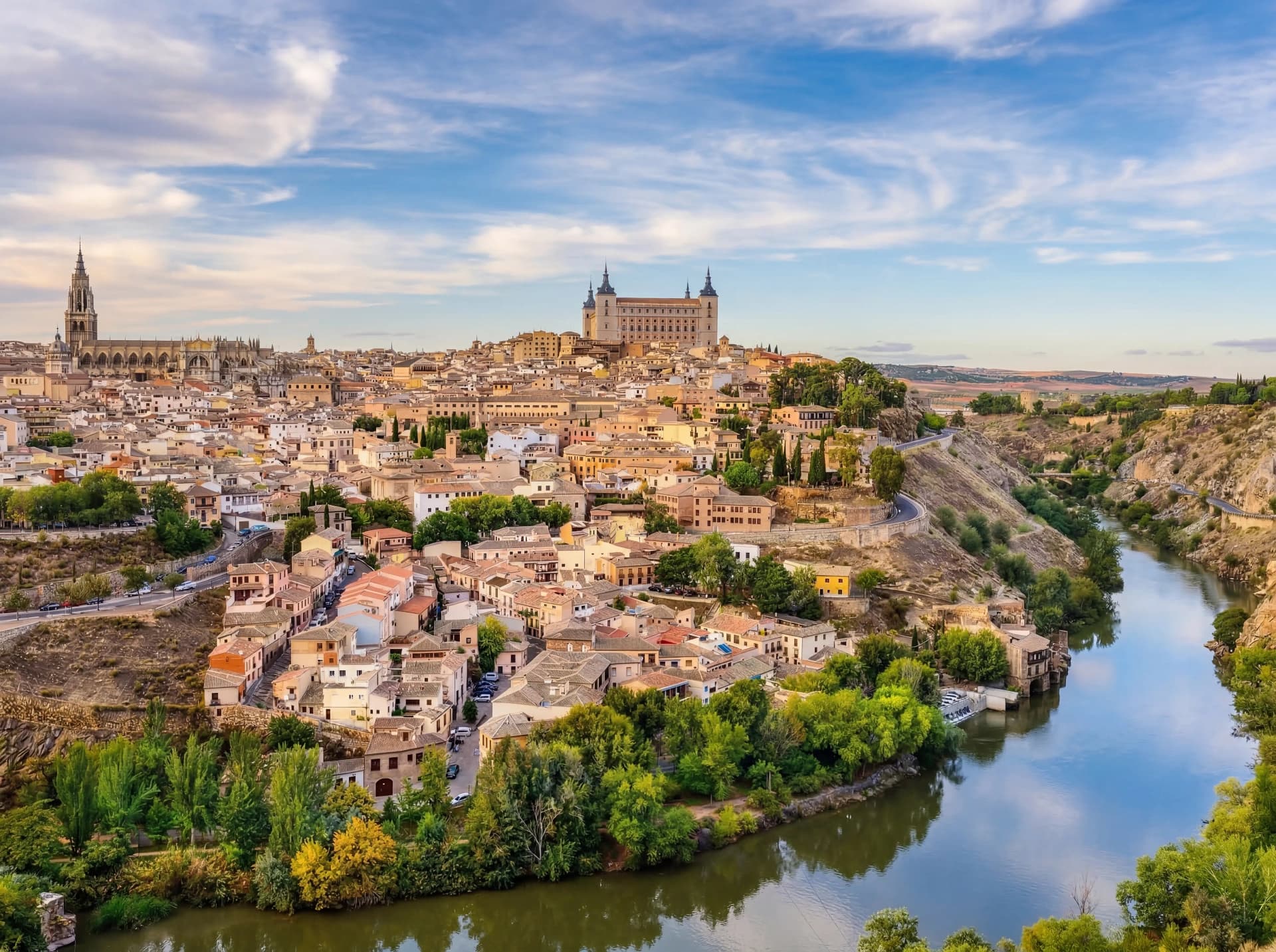 Panorámica aérea de Toledo al amanecer con el río Tajo rodeando el casco histórico medieval, vista desde el Mirador del Valle
